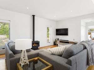 a living room with a gray couch and a fireplace at You Me And The Sea Blairgowrie in Blairgowrie