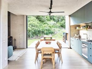 a kitchen and dining room with a table and chairs at The Bach St Andrews Beach in Saint Andrews Beach