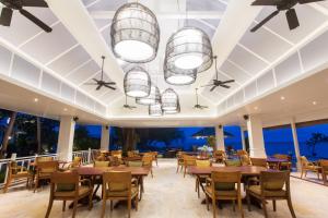 a restaurant with tables and chairs and windows at Rocky's Boutique Resort - Veranda Collection Samui in Lamai