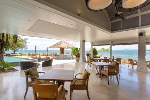 a restaurant with tables and chairs and a view of the ocean at Rocky's Boutique Resort - Veranda Collection Samui in Lamai