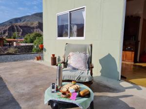 una silla y una mesa con comida. en Rikra Purmamarca en Purmamarca