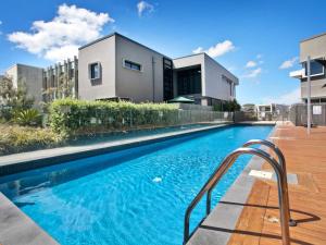 a swimming pool in front of a house at Marina View in Safety Beach