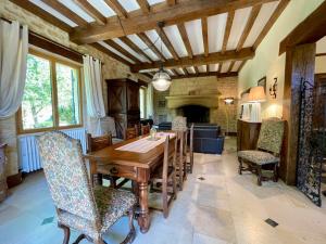 uma sala de jantar com uma mesa e cadeiras e uma lareira em Villa Joséphine - Maison de Charme à Beynac em Beynac-et-Cazenac
