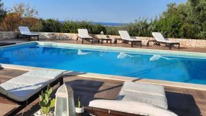 a swimming pool with chaise lounges and chairs around it at Villa Mest Pepp in Monopoli