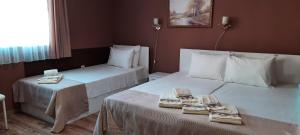 two beds in a hotel room with towels on them at MARIANA - Luxury stay private guest rooms in Gotse Delchev