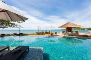 a swimming pool with chairs and umbrellas and the ocean at Rocky's Boutique Resort - Veranda Collection Samui in Lamai