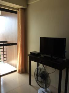 un salon avec une télévision et une table avec un ventilateur dans l'établissement Casa Bel, à Baguio