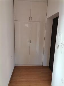 a room with white cabinets and a wooden floor at Апартамент Стил in Velingrad
