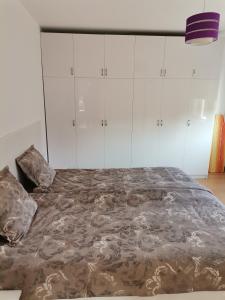 a large bed in a room with white cabinets at Апартамент Стил in Velingrad