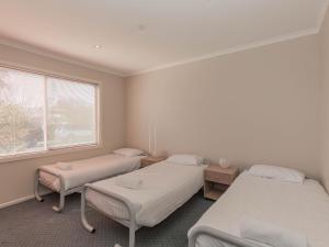 une chambre à l'hôpital avec trois lits et une fenêtre dans l'établissement 2 Munyang Street, à Jindabyne