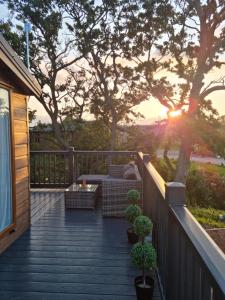 a deck with a couch and a table and trees at Foxwood Lodge Private Hot Tub Getaway in Swarland