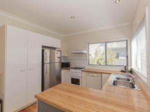 a kitchen with a sink and a refrigerator at Aspect 1 8a Poley Cow Lane in Jindabyne