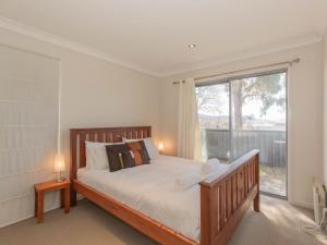 a bedroom with a bed and a large window at Aspect 1 8a Poley Cow Lane in Jindabyne