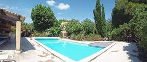 una grande piscina blu in un cortile di Offrez-vous un séjour dans notre gîte à Entressen Une grande piscine pour se rafraîchir ,un espace de jeux pour enfants pour des heures de divertissement Un terrain de pétanque pour des parties endiablées a Entressen