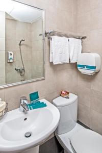 a bathroom with a sink and a toilet and a mirror at Hotel 81 Balestier in Singapore