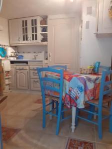 a kitchen with a table with blue chairs and a tableablish at L'Oustalet in Beaumes-de-Venise