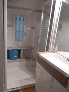 a white bathroom with a sink and a shower at L'Oustalet in Beaumes-de-Venise