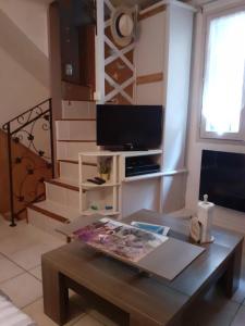 a living room with a coffee table and a tv at L'Oustalet in Beaumes-de-Venise