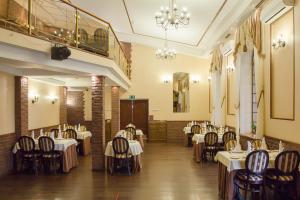 a dining room with tables and chairs and a chandelier at Hotel Piipun Piha in Sortavala