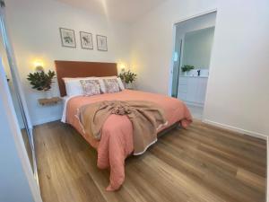 a bedroom with a bed and a wooden floor at Flower Farm Tamborine Mountain in Mount Tamborine