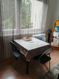 einen Tisch mit Stühlen vor einem Fenster in der Unterkunft Var Apartman in Miskolc