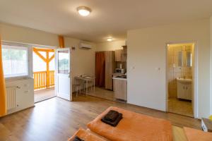 a living room with a couch and a kitchen at Montana-Ederics Vendégház in Balatonederics