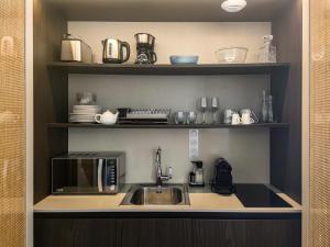 a kitchen with a sink and a microwave at Aparthotel AMMI Vieux Nice in Nice