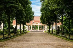 a driveway leading to a large house with trees at Hotel Kurhaus Bad Bocklet in Bad Bocklet