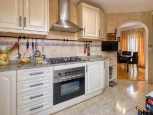 a kitchen with white cabinets and a stove top oven at El Descanso in Gata de Gorgos