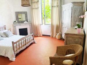 a bedroom with a bed and a chair and a fireplace at Bed & Breakfast Chambres d'hôtes COTTAGE BELLEVUE in Cannes