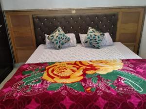 a bed with a bedspread with flowers on it at Mount Valley Mama Cottage in Rishīkesh