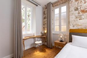 a bedroom with a bed and a desk and a window at Acanthus blue in Corfu