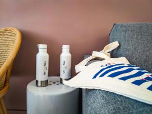 two bottles of water are sitting next to a chair at Aparthotel AMMI Vieux Nice in Nice