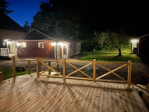 uma pequena casa num convés à noite em Almas gård em Ullared