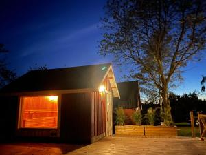 uma pequena casa com luzes ao lado em Almas gård em Ullared