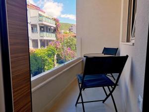 d'une table et d'une chaise sur un balcon avec une fenêtre. dans l'établissement Apartments LORA Zmajeva, 7, à Budva