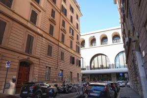 una strada cittadina con auto parcheggiate accanto agli edifici di Archi di Roma Guest House a Roma