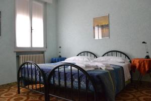 マントヴァにあるLa Buonanotteのベッドルーム1室(ベッド2台、青い毛布、窓2つ付)