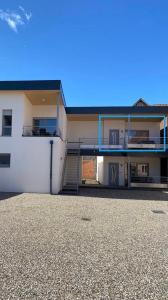 ein weißes Gebäude mit einem Balkon und einer Treppe in der Unterkunft Sollaris Appartement 1ère étage à 11km de Europa-Park in Friesenheim