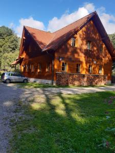 a wooden house with a car parked in front of it at Schutzhaus Johannesbachklamm in Unterhöflein