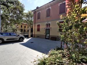 une voiture garée dans un parking à côté d'un bâtiment dans l'établissement La Bella Modena Centro, à Modène