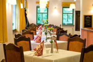 a dining room with tables and chairs with flowers on them at Gutshof Hauber in Dresden