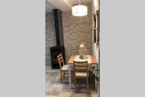 uma sala de jantar com mesa e cadeiras e uma parede de tijolos em Casa Fineta em Algar de Palancia