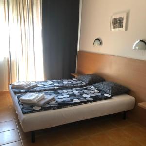 a bed in a room with two pillows on it at Csorvy Apartman in Hajdúszoboszló +13 photos