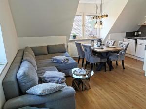 a living room with a couch and a table at Moderne Wohnung mit Privatpool in Büsum