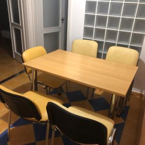a conference room with a wooden table and chairs at Csorvy Apartman in Hajdúszoboszló
