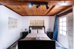 バレッタにあるValletta Collection - St Pauls Apartmentの木製の天井のベッドルーム1室(大型ベッド1台付)