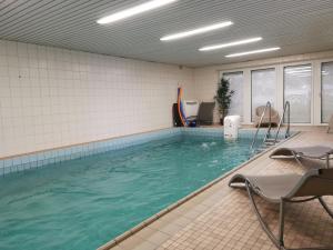 una piscina con sedie in camera di Moderne Wohnung mit Privatpool a Büsum