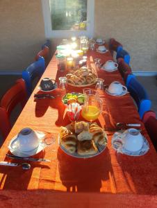 uma mesa longa com pratos de comida em Villa des masques em Aubais