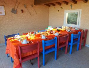 una mesa de comedor con mesas y sillas rojas y azules en Villa des masques, en Aubais
